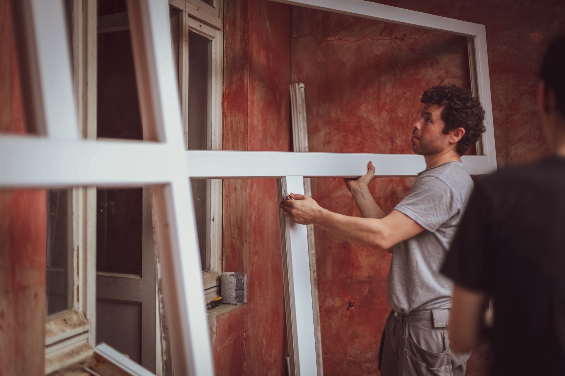 Le constructeur de race blanche porte des cadres de fenêtres.